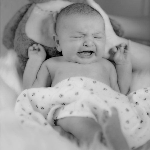 Baby mit KiSS Syndrom liegt und schreit