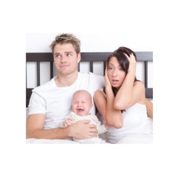 Eltern verzweifelt sitzen im Bett mit Schreibaby